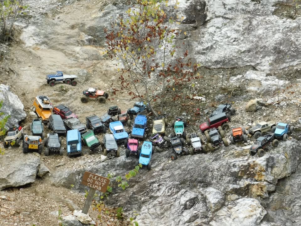 Dozens of remote-control rock crawler vehicles gathered on the rocky terrain of Ruggles Mine in Grafton, New Hampshire during an RC crawling event.